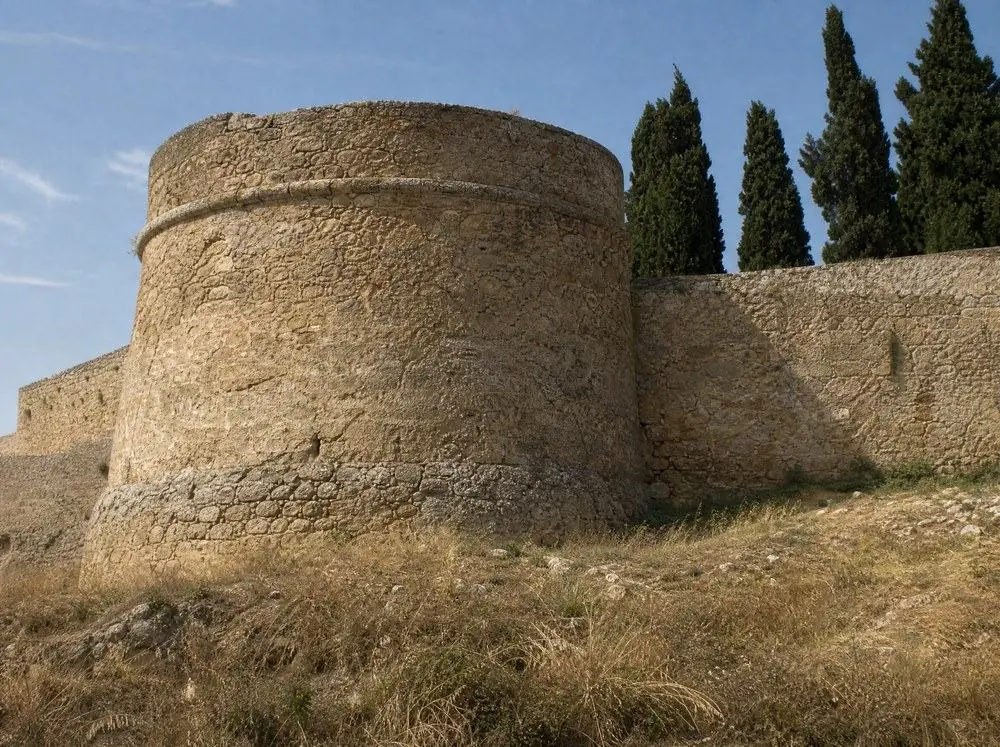 A round corner tower and curtain wall of a medieval hilltop castle
